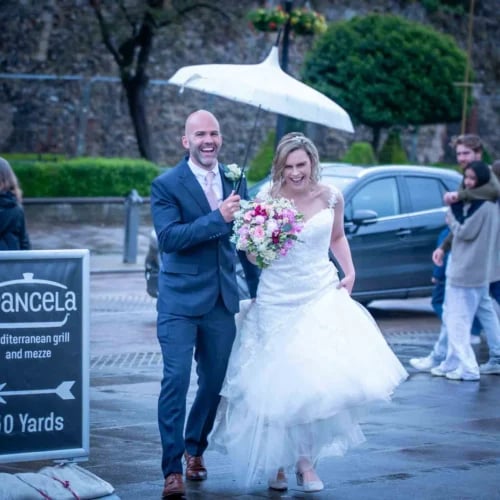 a bride and groom walking down the street
