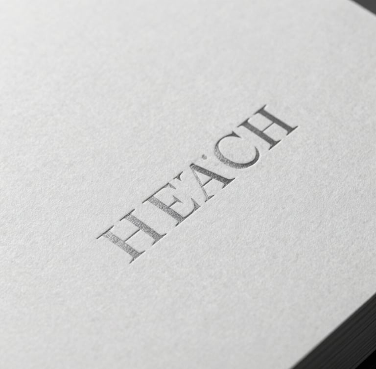 Tight macro shot of a monochrome book cover with blind-debossed serif typography, soft side shadow, premium textured paper