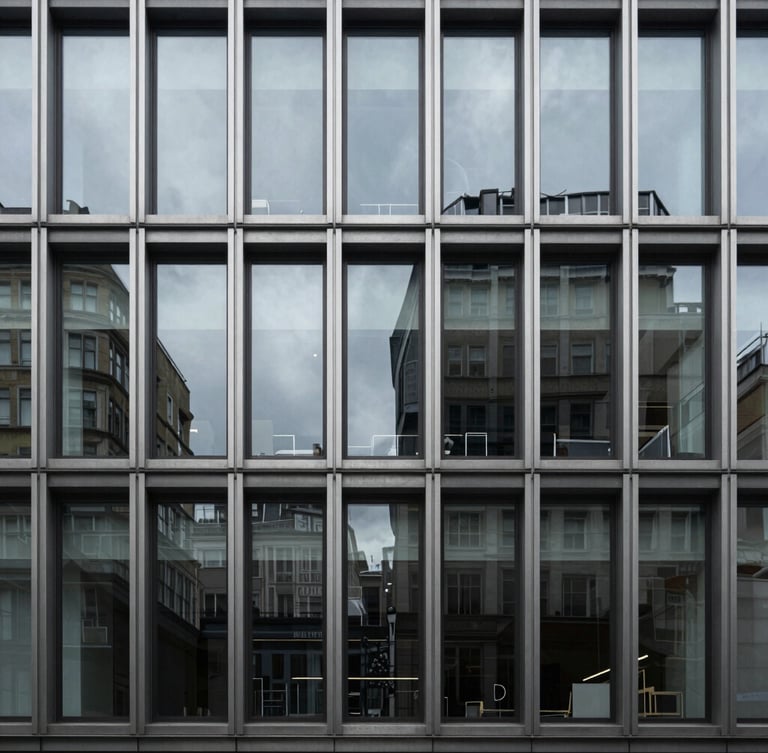 Cool architectural photography of a minimalist London office facade, sharp window reflections, desaturated steel tones, 35mm