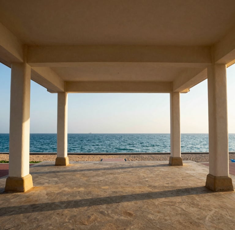 Wide-angle architectural shot of the open-air pavilion structure at Gangothri HarbourFront, showing its clean lines framing the Arabian Sea at late afternoon sun, with subtle maritime details of Puthiyappa Harbour visible.
