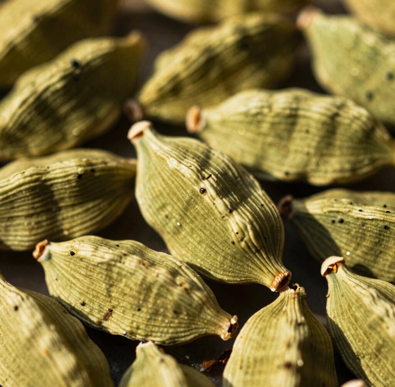 Macro shot of whole green cardamom pods in warm golden-hour sunlight, showing natural textures and fine details, 35mm film
