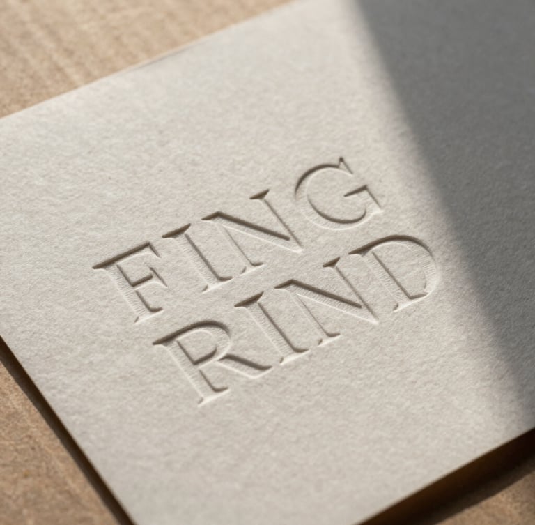 Close-up of embossed typography on heavy textured paper resting on raw cardboard, high-contrast natural light casting sharp shadows.