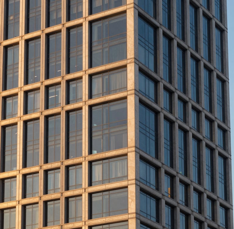 Elegant architectural detail of a modern glass and steel skyscraper facade in Miami, warm golden hour light reflecting off the windows, clean editorial composition