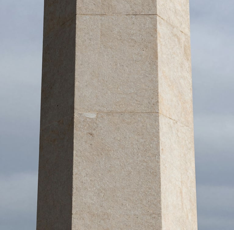 Extreme close-up of a monolithic limestone pillar, sharp shadows, overcast daylight, minimalist architectural texture.