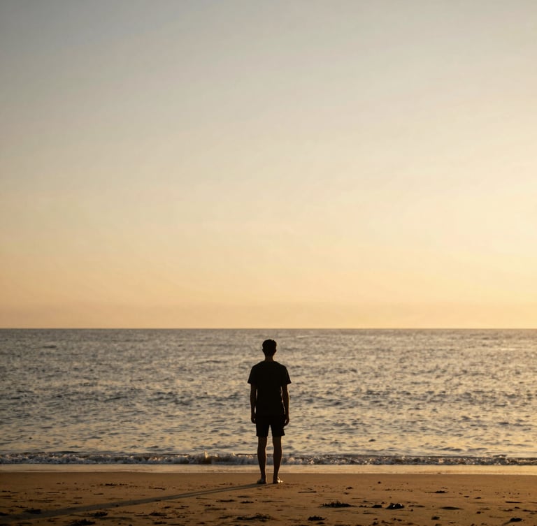 Solitary figure in silhouette, standing on a beach at golden hour, looking out at the vast ocean horizon, expansive sky, warm light.