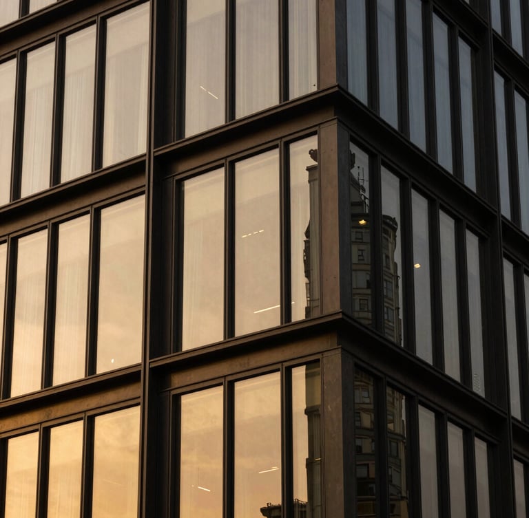 Close-up architectural detail of a modern luxury building facade, sharp angles, dark steel and gold-tinted glass under dramatic high-contrast lighting