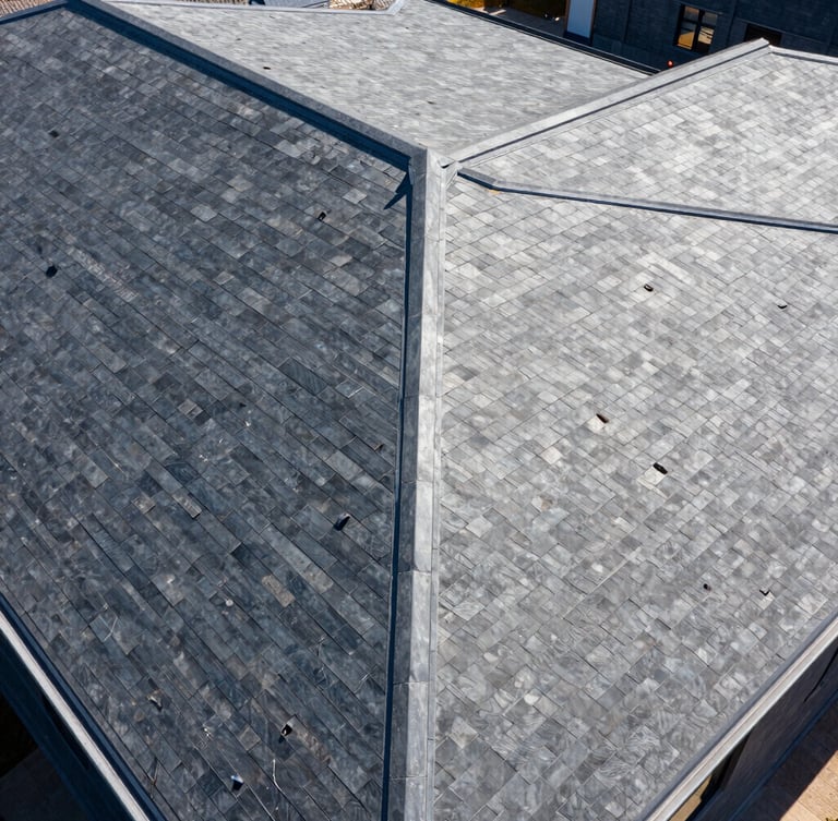 Wide-angle architectural drone shot of a flawless slate-gray roof, bright midday sun, high-contrast crisp shadows, sharp detail