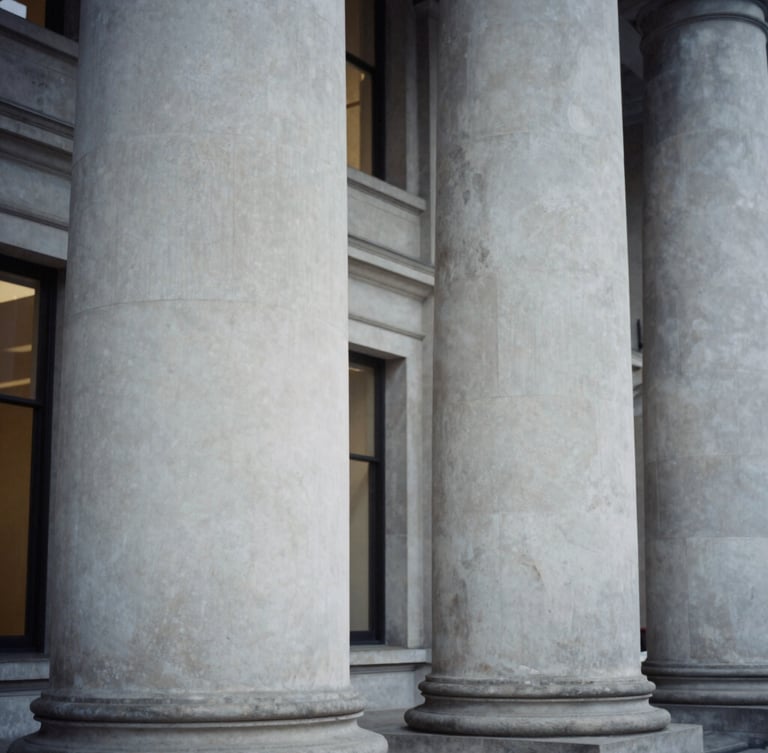 Close-up editorial corporate photograph of structured Portland stone pillars in London, soft interior window light, desaturated cool tones, architectural framing, 35mm film.