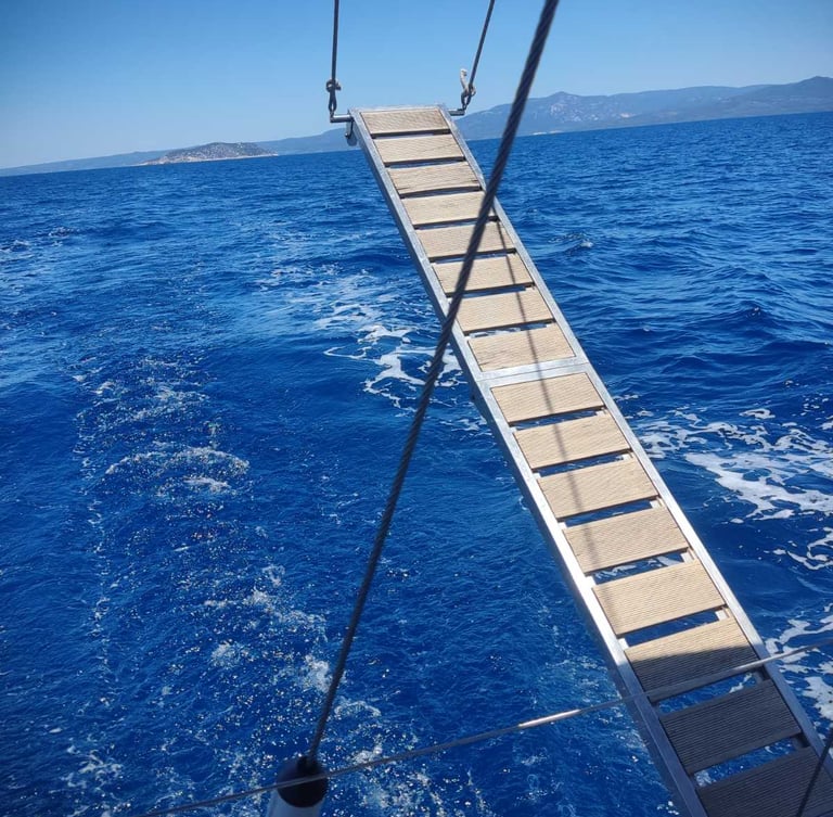 Swimming ladder over the crystal-clear Aegean Sea during a private sailing cruise in Halkidiki