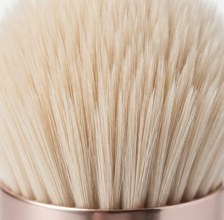 Macro close-up of premium synthetic makeup brush bristles, highlighting ultra-fine tip alignment and dense packing, bright high-key studio lighting, minimalist white background