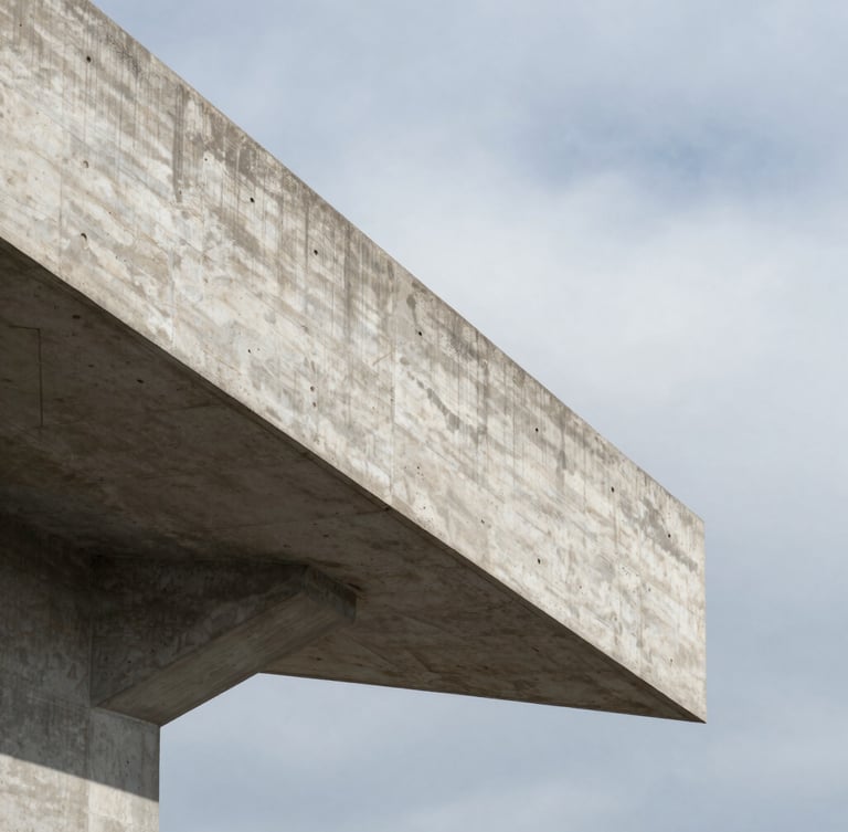 A sharp vertical close-up of a reinforced concrete cantilever beam projecting into empty space, cast shadows, overcast sky