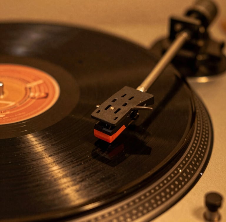 Close-up macro shot of a vintage turntable needle resting on a spinning vinyl record, warm low-key studio lighting with amber glow, shallow depth of field, 35mm