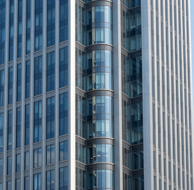 Symmetrical modern architectural perspective of a financial district skyscraper, clean steel and glass lines, bright natural daylight, cool blue and slate tones, sharp focus