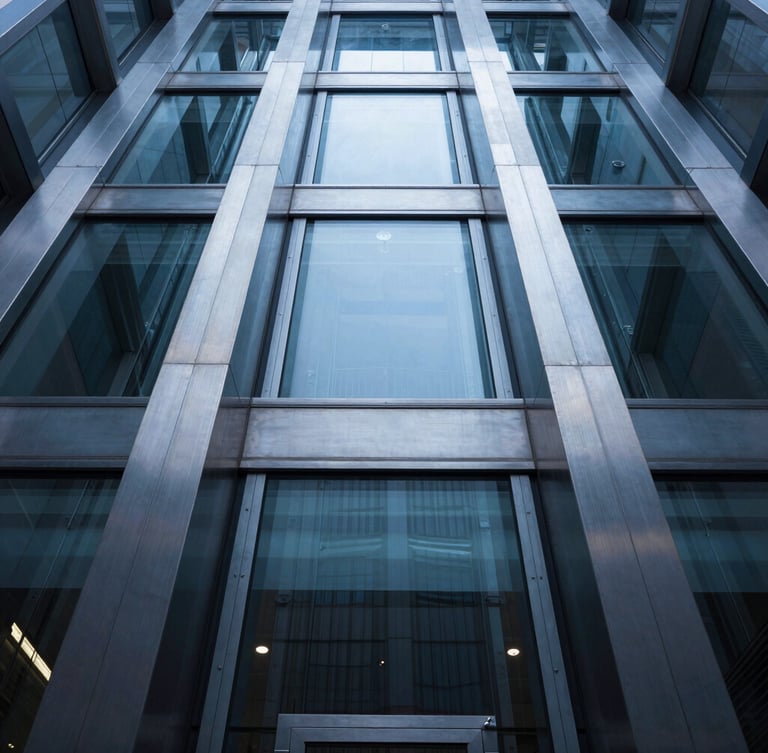 Low-angle architectural shot of a modern glass elevator shaft, cool crisp daylight reflecting on brushed steel rails, symmetrical composition.