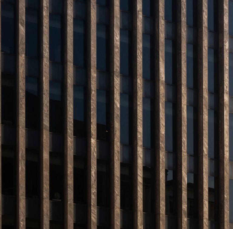 Architectural detail of a sober corporate building in São Paulo, sharp directional afternoon light, deep navy shadows, minimalist composition, 35mm