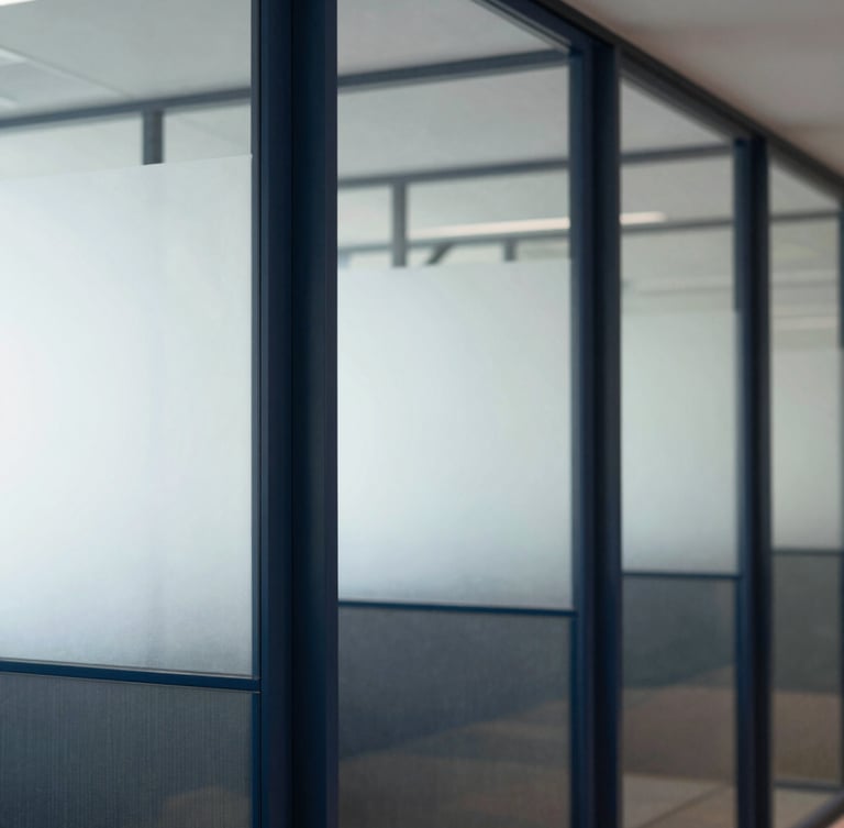 Portrait crop of a clean, modern financial office interior, focus on architectural glass partitions, soft natural daylight, deep navy and slate tones.