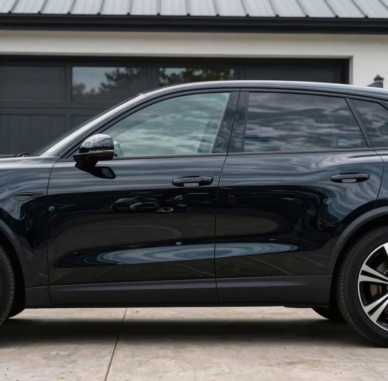 Side profile of a premium vehicle with flawless dark tinted windows parked on a clean modern driveway in Essex, crisp reflections