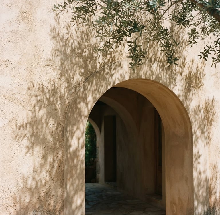 Soft natural sunlight casting olive leaf shadows on a warm stucco wall, minimalist Mediterranean architectural arch, sand tones, 35mm photography