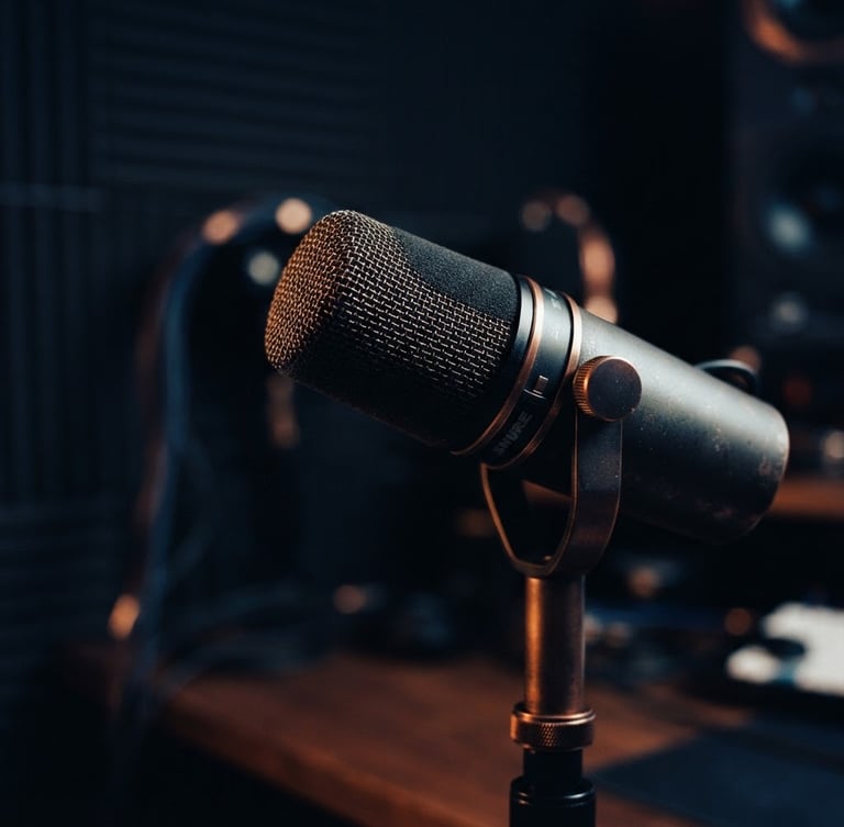 High-quality studio microphone, close-up, moody directional studio lighting, warm highlights, shallow depth of field, 35mm, deep navy and copper tones, off-center to the right.