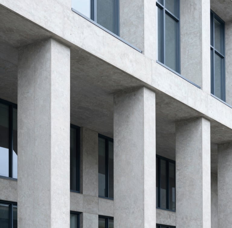 Crisp architectural crop of a modern civic building with concrete pillars, bright neutral daylight, clean lines, desaturated corporate blues, high detail, 35mm