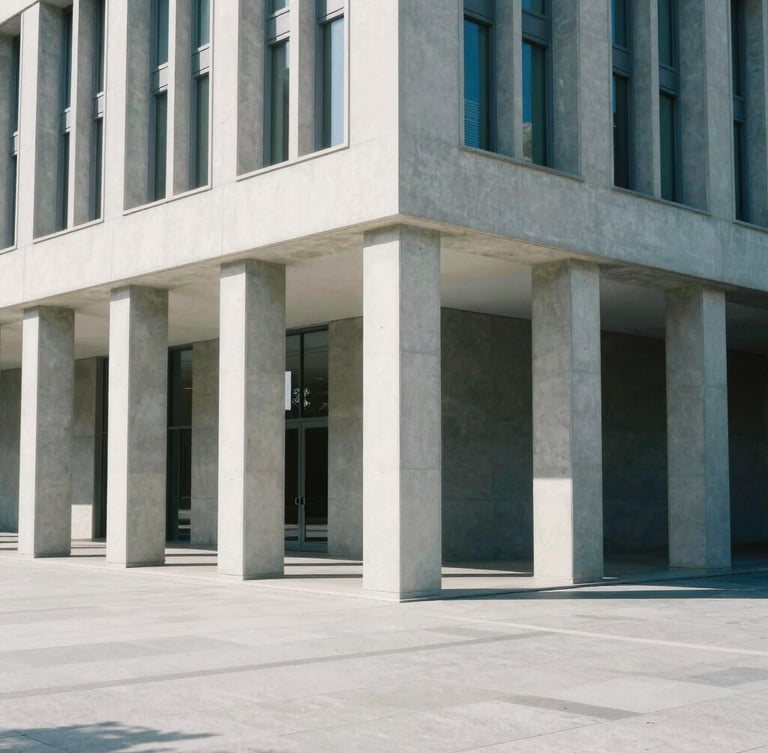 Wide architectural angle of a modern civic building with clean concrete columns, bright neutral daylight, sharp clean shadows, desaturated blues and grays