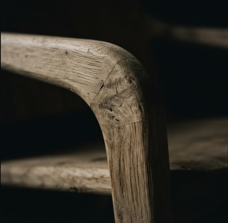 Extreme close-up of a minimalist lounge chair, raw oak grain-matched wood texture, dramatic low-key studio lighting with deep shadows, 35mm lens, cinematic depth of field.