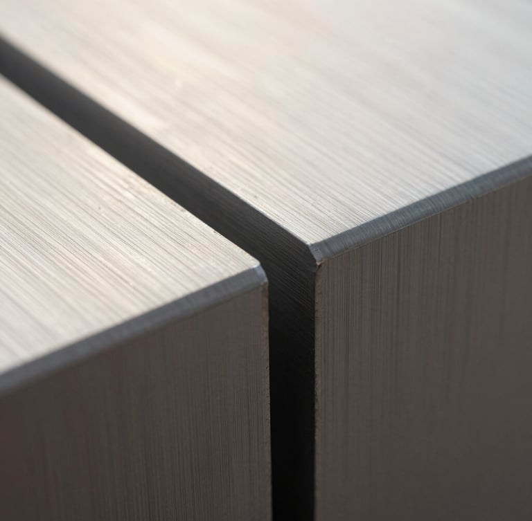 Macro photograph of a milled aluminum seam under soft morning light, showing precise metallic grain and a brushed finish, minimalist composition.