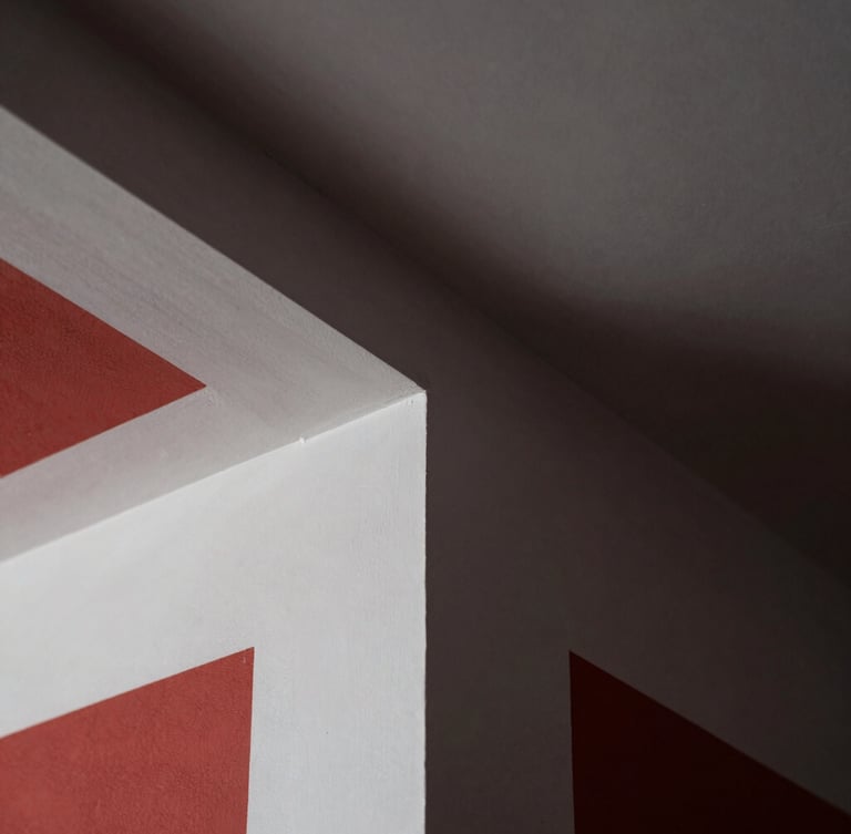Extreme close-up of a perfectly smooth drywall corner joint, dramatic raking light highlighting clean geometric lines, white-gray plaster texture, sharp focus