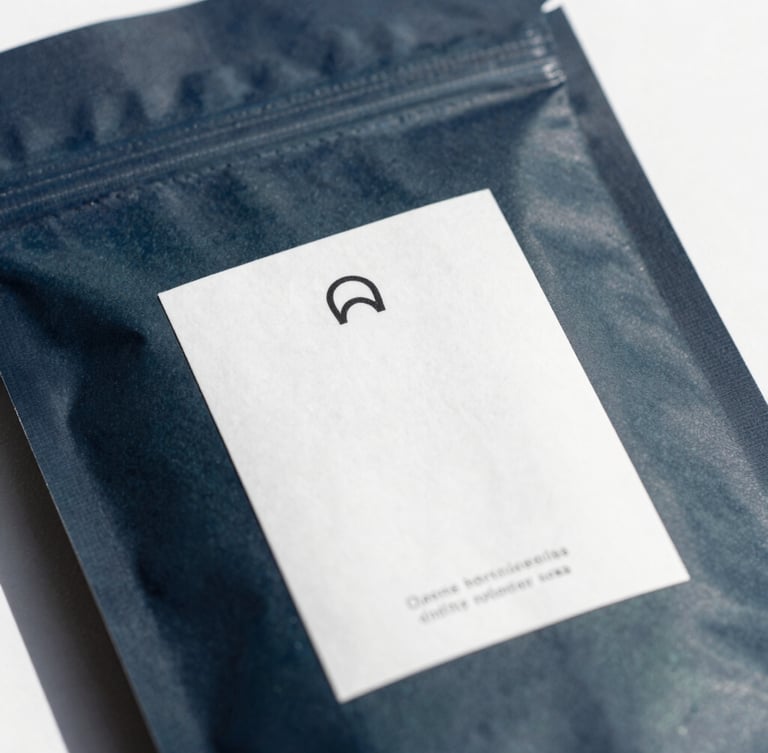 Macro close-up of high-end apparel packaging with clean minimalist labeling, cool natural daylight, high-contrast shadows, 35mm lens