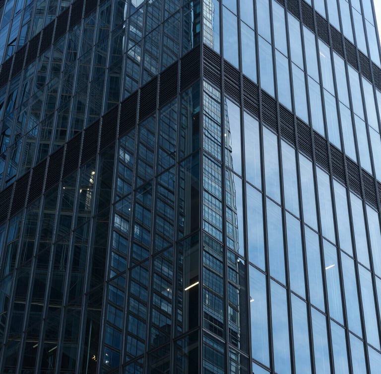 Extreme close-up of a glass skyscraper facade reflecting sharp geometric patterns and deep blue light, high contrast.