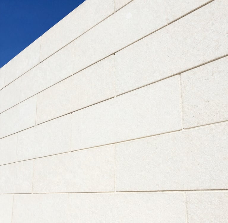 Close-up macro shot of clean, light-colored stone masonry with precise, newly sealed grout lines under high-key commercial lighting