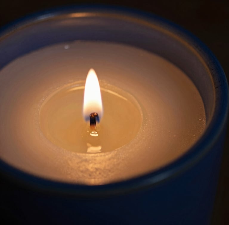 Macro editorial photograph of warm golden candle wax pooling inside a deep blue ceramic vessel, low-key candlelight, soft shadows, shallow depth of field.