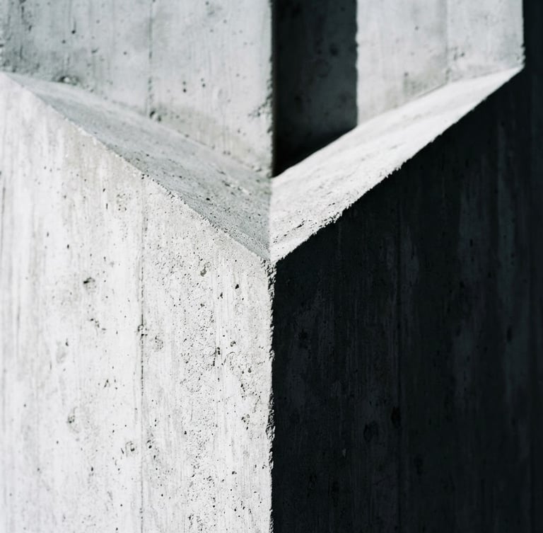 Extreme close-up of a sharp architectural concrete corner, dramatic natural light casting deep geometric shadows, 35mm lens, high-contrast cool tones.