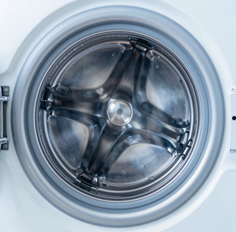 Symmetrical close-up of a gleaming stainless steel washing drum, bright high-key studio lighting with cool blue undertones, sharp macro focus