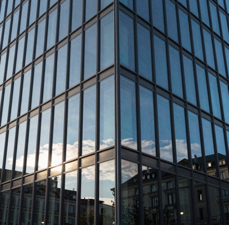 Photographie en gros plan de l'angle d'un bâtiment moderne en verre à Genève, reflets nets du ciel bleu, ombres géométriques précises, style suisse.