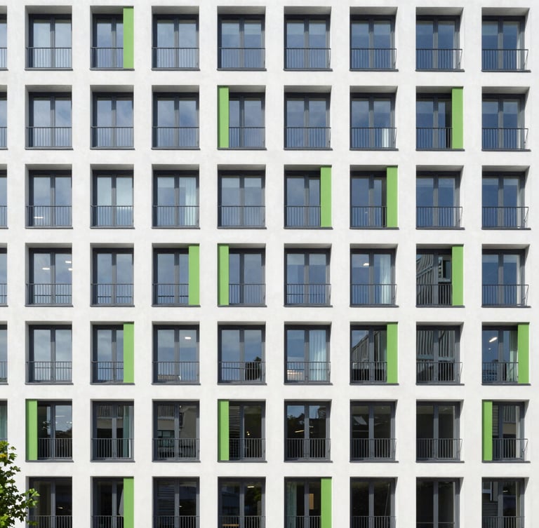 Wide architectural photograph of a modern multi-family apartment building in Frankfurt, clean modern facade, bright daylight, sharp focus, 35mm