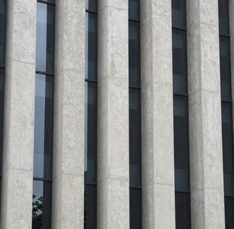 Symmetrical architectural crop of towering concrete columns and glass panels under overcast light, clean structural lines