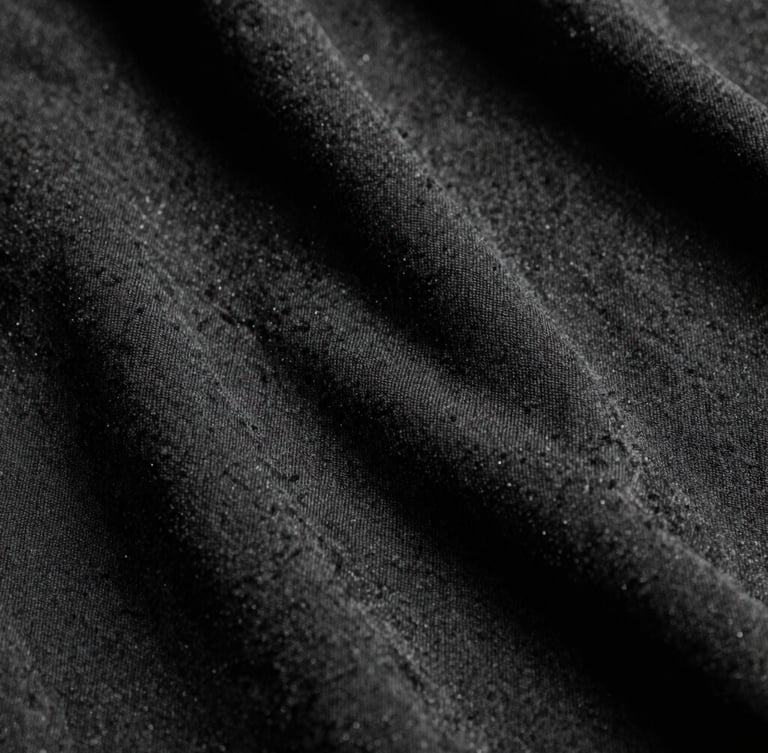 Extreme macro close-up of high-density black heavyweight cotton fabric texture, harsh direct studio lighting, deep shadows, 35mm film