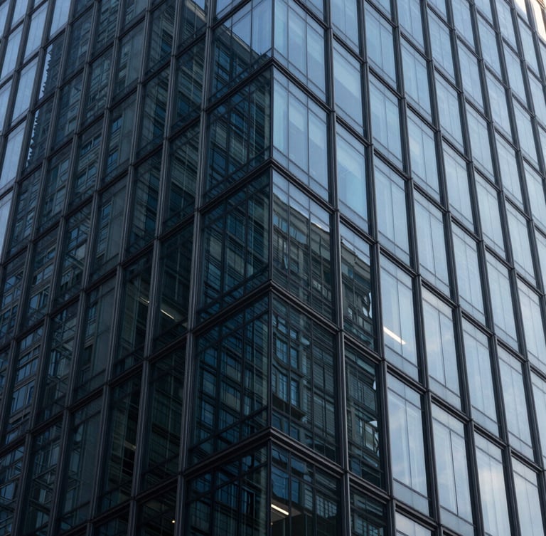Macro photograph of clean modern glass skyscraper facade reflecting cool morning light, sharp geometric angles, deep navy tones, 35mm