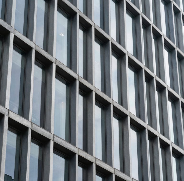 A close-up architectural crop of a modern steel and glass building facade, clean geometric lines, crisp daylight