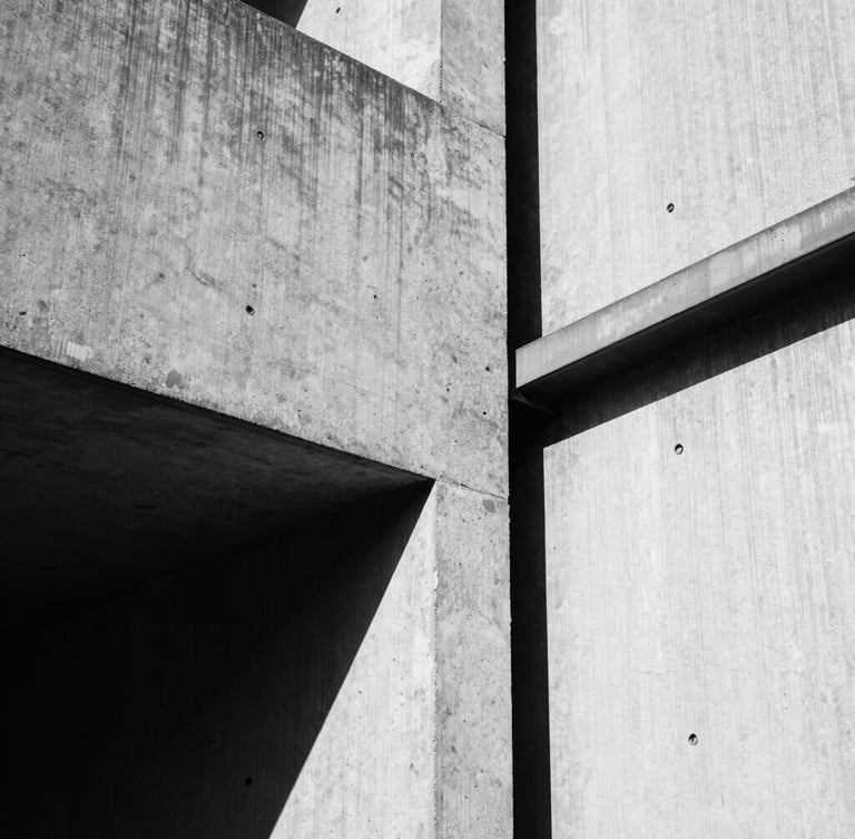 Stark brutalist photography, harsh industrial shadows, high-contrast black and white, close-up of raw textured concrete meeting unpolished steel, 35mm