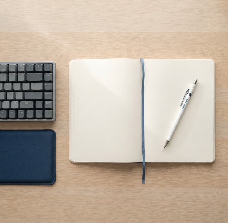 Overhead flat-lay of a clean minimalist desk setup, an open notebook with a mechanical pencil, a keyboard, bright diffused high-key natural light, soft shadows, desaturated tones with blue accent, 35mm
