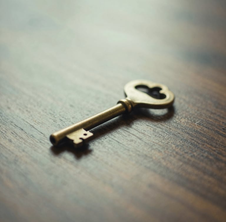 Medium close-up of a heavy brass key resting on a polished dark wood surface, soft natural morning light, shallow depth of field. Muted forest green and cream tones.