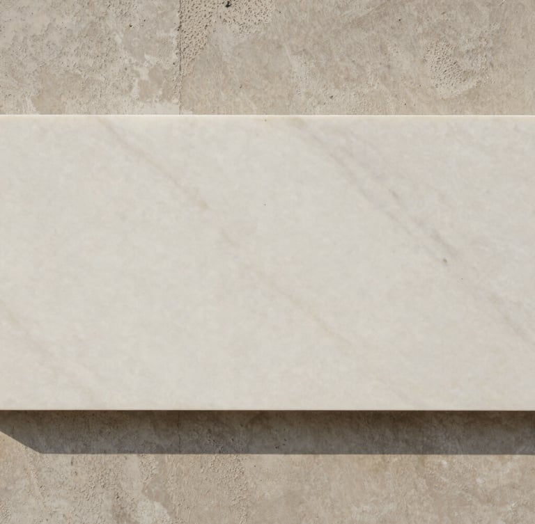 Abstract close-up of raw materials, a slab of honed white marble resting against textured cast concrete, soft natural side lighting, neutral tones