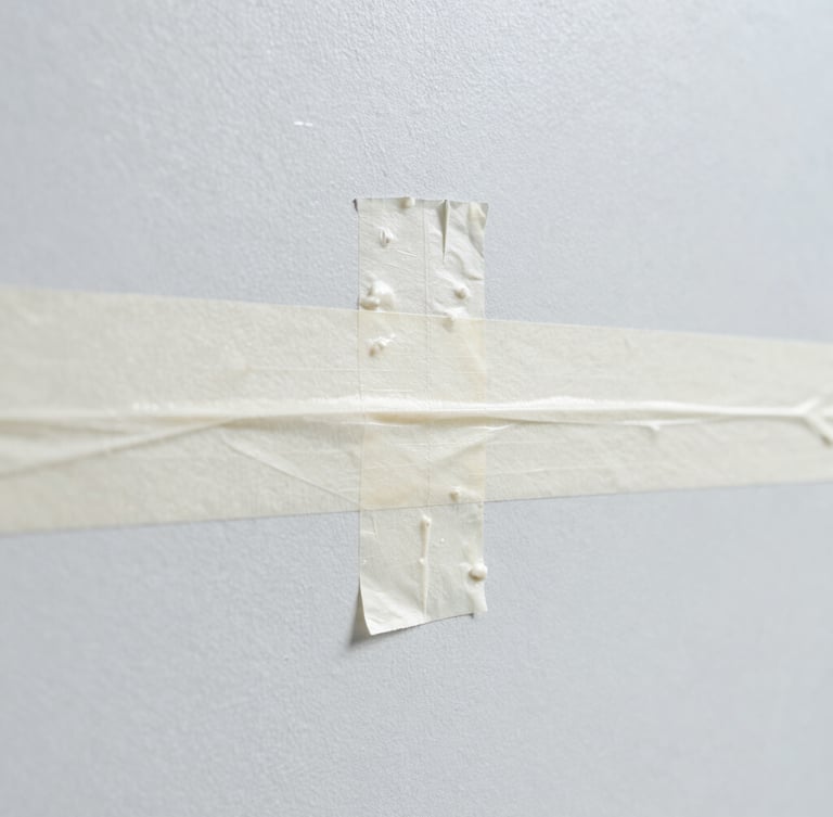 Macro shot of a clean paint line being taped off on a smooth wall, sharp focus, bright daylight, high-contrast cool tones