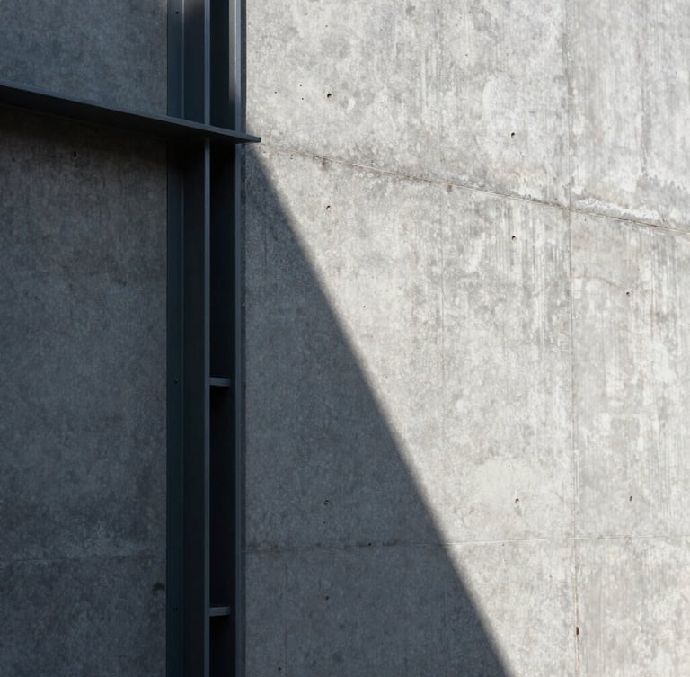 Vertical close-up of a raw concrete wall intersecting with a dark steel frame, sharp geometric sunlight casting a diagonal shadow, strict one-point perspective