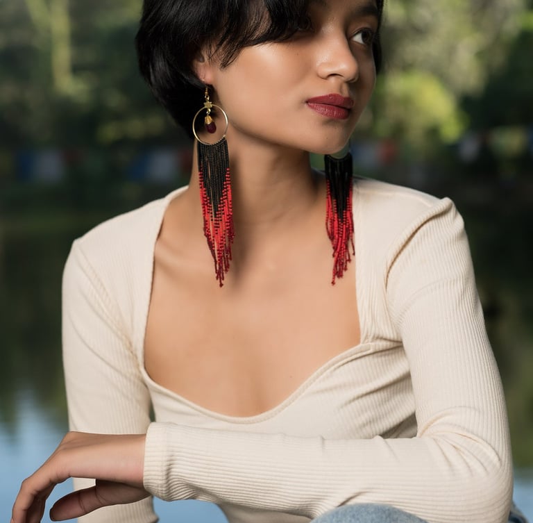 a woman with a long black hair and earrings