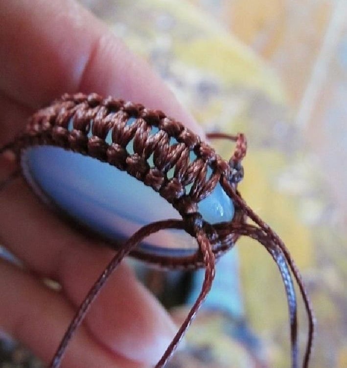 Un colgante de joyería personalizado está hecho a mano con un nudo de macramé marrón