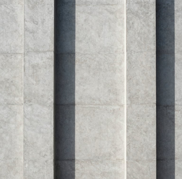Perfectly centered architectural detail of a concrete facade, sharp linear shadows dividing the frame, clean minimalist geometry.