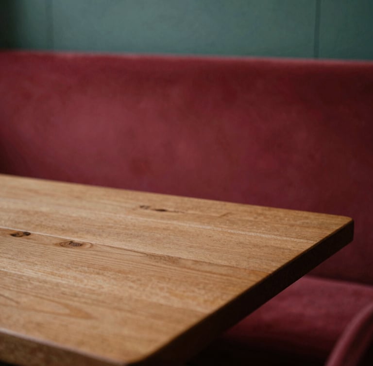 A cozy Scandinavian-style restaurant interior with soft, diffused side-lit daylight illuminating a rustic wooden table, shallow depth of field, warm editorial photography.